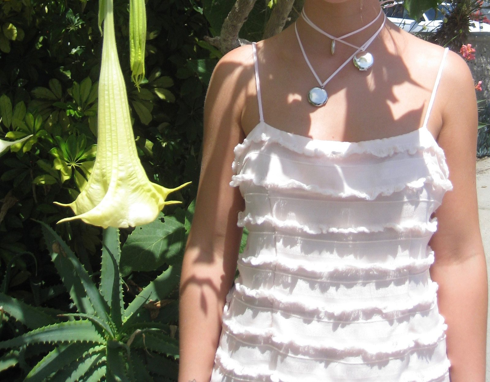 Layered necklace with round silver lockets, white dress