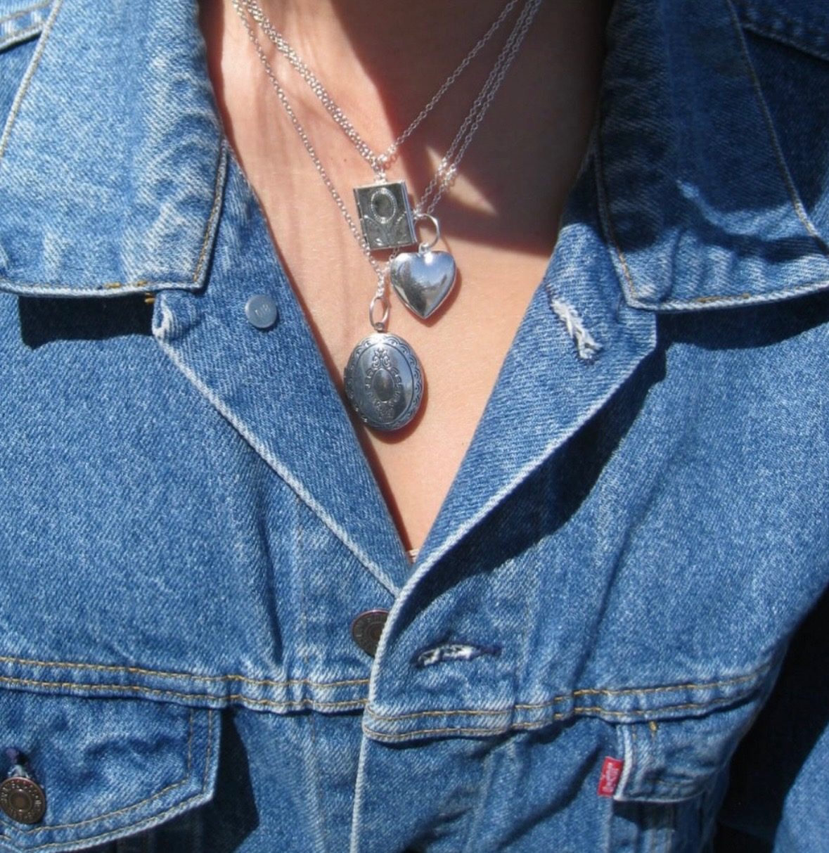 Layered locket necklaces with a denim jacket